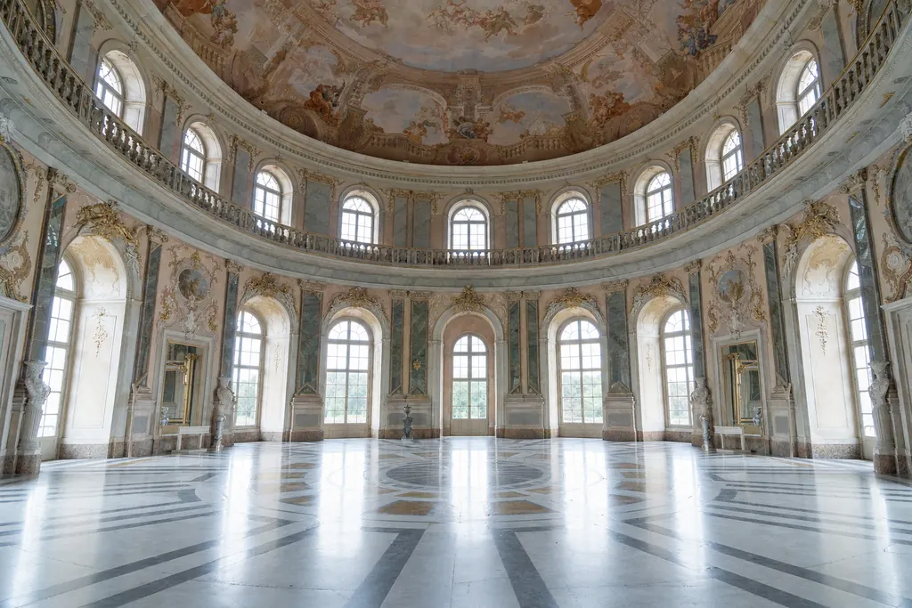 Grande salone ovale barocco con cupola affrescata, finestre ad arco e pavimento in marmo (immagine creata con AI)